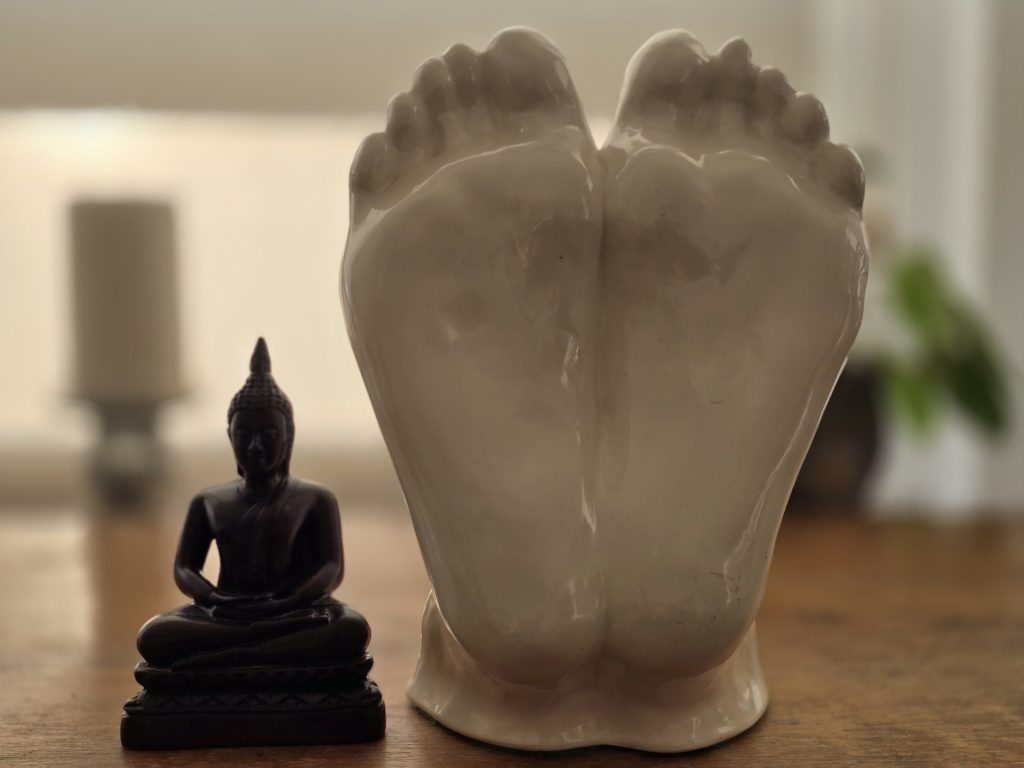 Statue of feet next to a buddha